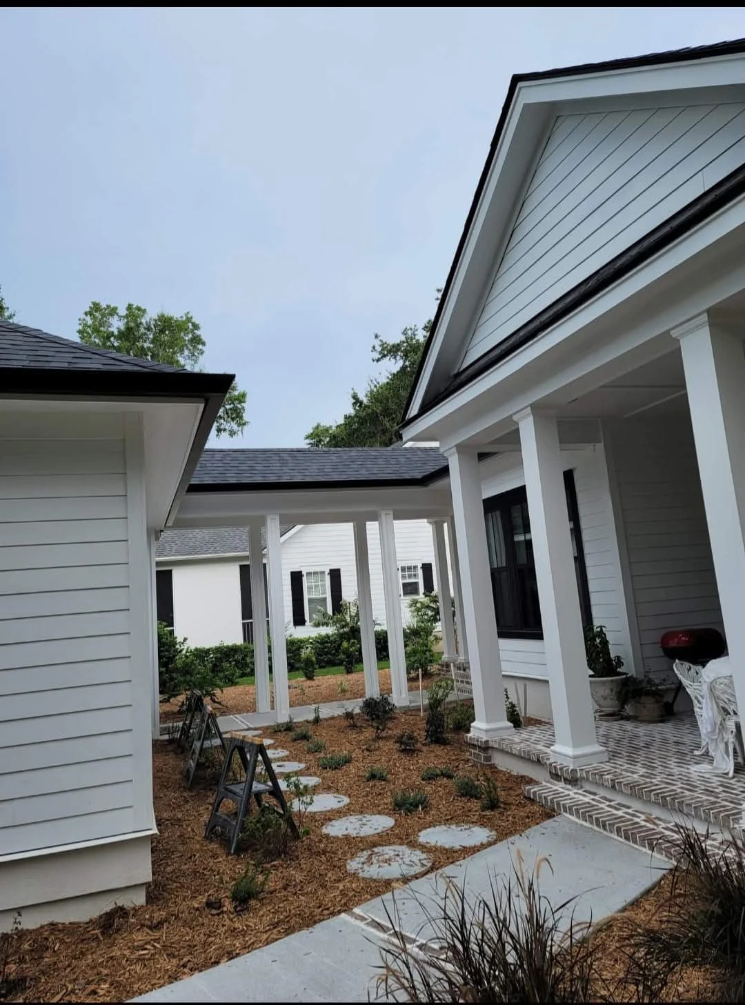Black seamless gutters installed along a hip roof cottage in Beaufort, South Carolina
